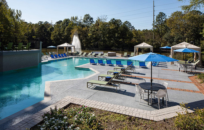 a swimming pool with lounge chairs and umbrellas