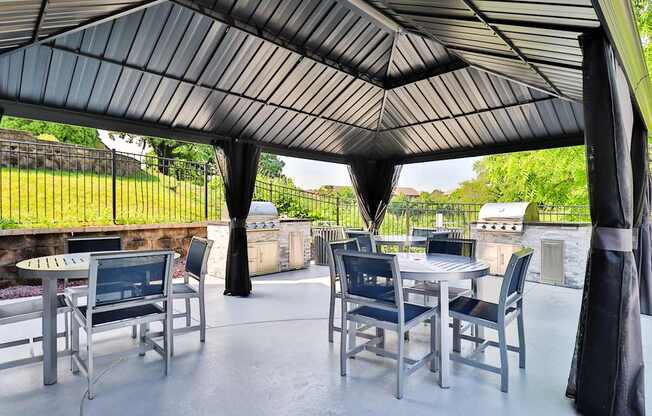 A patio with a table and chairs under a black canopy.