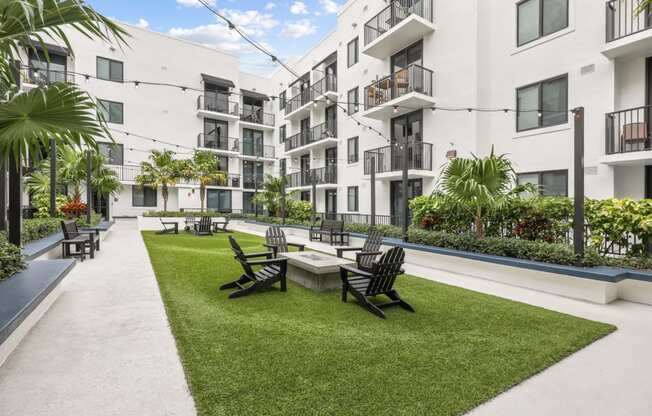 a courtyard with a table and chairs in front of some apartments