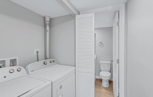 a washer and dryer in a laundry room next to a toilet