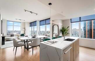 A modern kitchen with a marble island and a dining table with chairs.