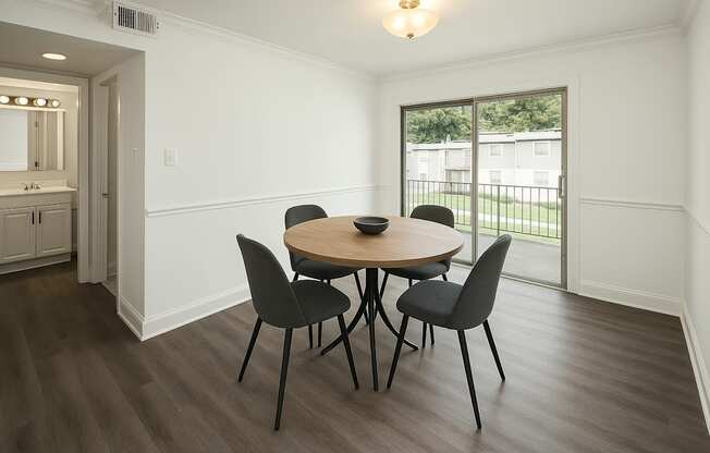 A dining room with a round table and four chairs.