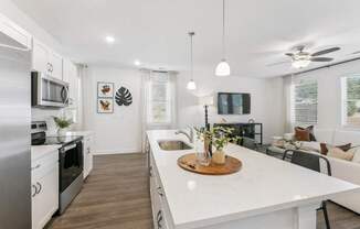 an open kitchen and living room with a large white counter top