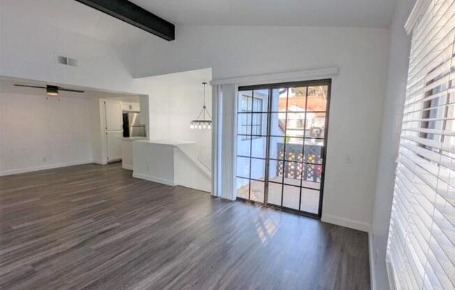 an empty living room with a door to a balcony  at The Resort at Encinitas Luxury Apartment Homes, Encinitas, 92024