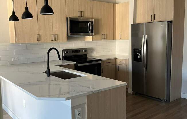 a kitchen with an island and a stainless steel refrigerator