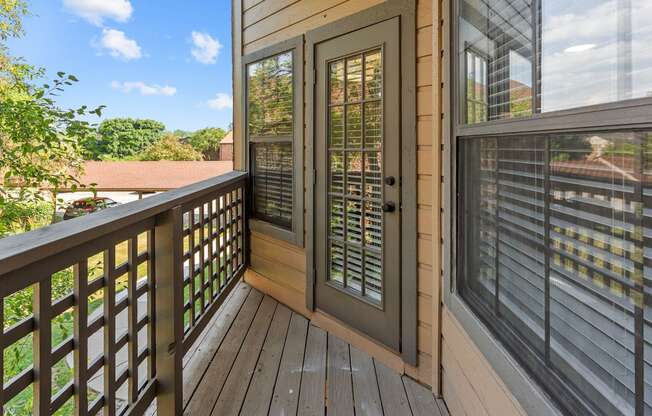 A wooden deck with a glass door and window.