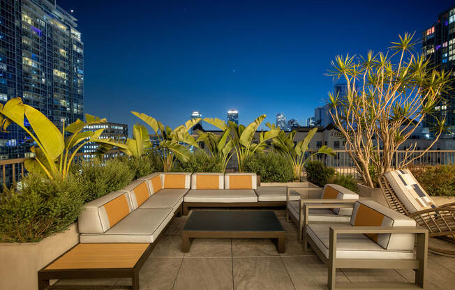 a lounge area on the roof of a building with a city in the background