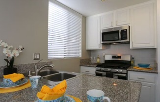 A kitchen with granite countertops and a stainless steel sink.