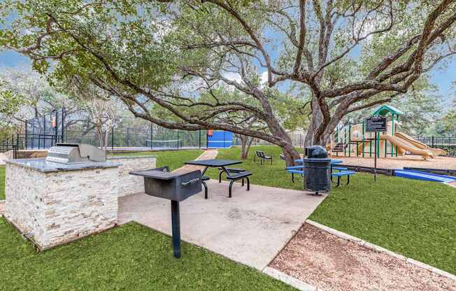 A park with a playground, picnic table, and a mailbox.