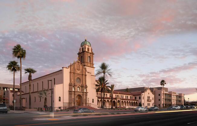 a church with a clock on the side of a road