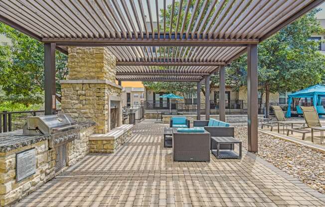 a covered patio with a grill and tables and chairs