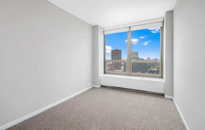 A room with a window overlooking a cityscape.