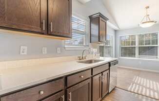 an empty kitchen with wooden cabinets and a sink