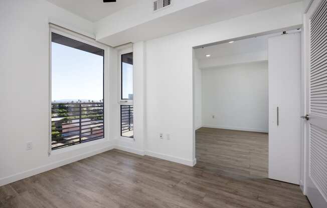 a living room with a large window and a door to a balcony