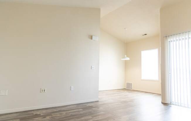 an empty living room with white walls and wood floors