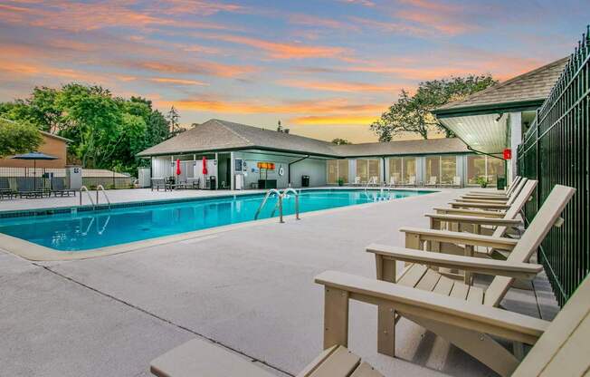 A poolside area with sun loungers and a building in the background.