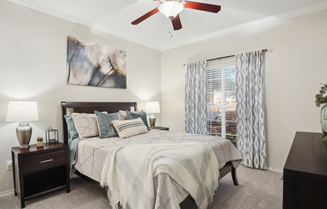a bedroom with a large bed and a ceiling fan at La Ventura Apartments, Texas, 75093