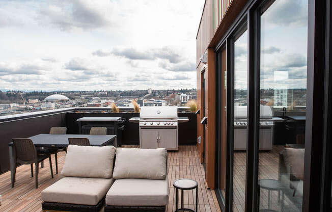 a deck on the roof of a building with furniture and a grill at Analog Tacoma, Tacoma