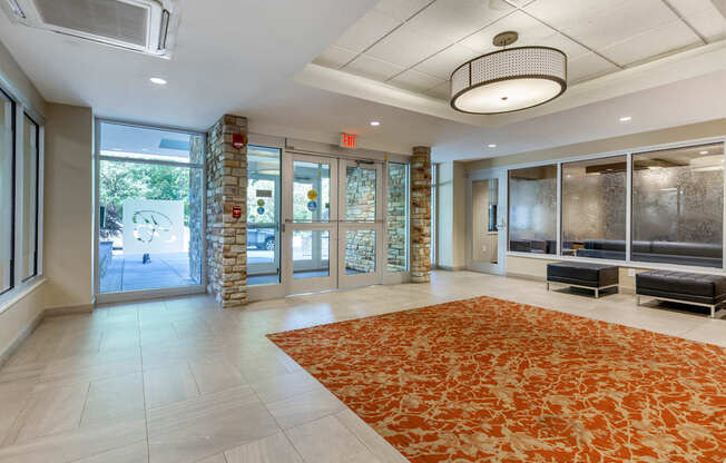 A large room with a rug on the floor and a stone pillar.