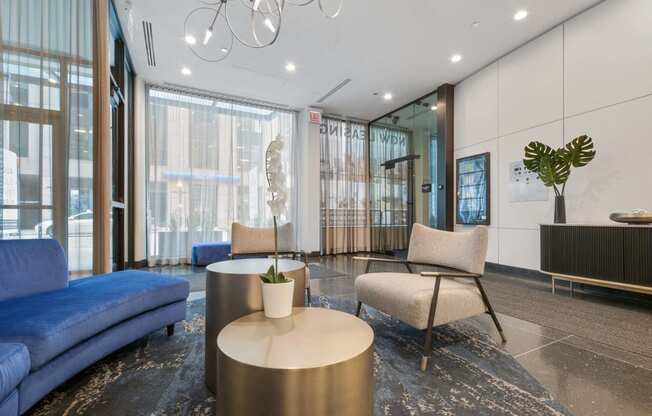 a lobby with blue couches and chairs and a table