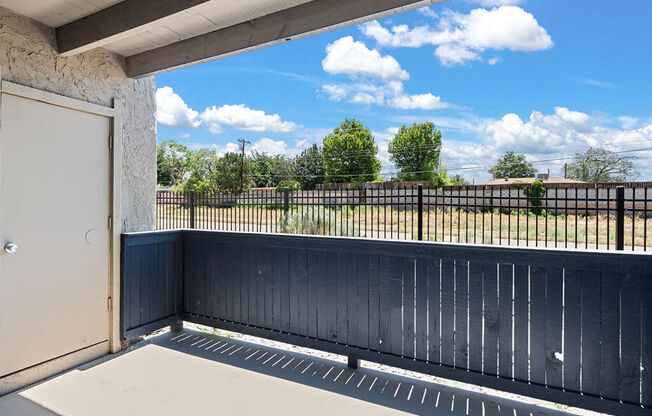 a view of a balcony with a blue sky and some clouds