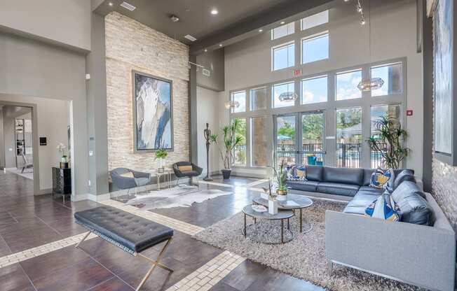 a living room with couches and tables and large windows