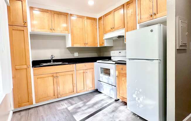 an empty kitchen with wooden cabinets and stainless steel appliances