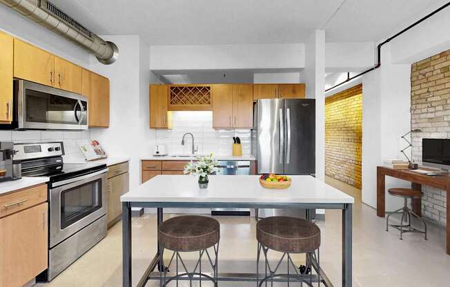 A modern kitchen with a table and chairs in the middle.