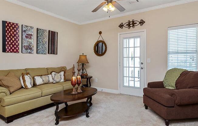 a living room with a couch and a chair at Bedford Parke Apartments, Warner Robins, GA 31088