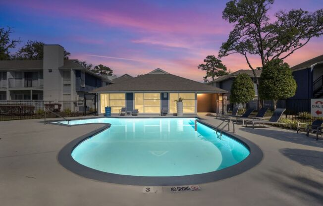 a pool with a building behind it at sunset