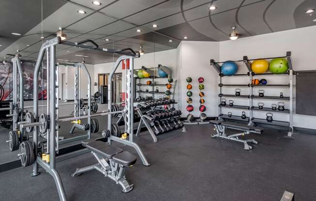 a gym with weights and racks of weights on the wall at Mockingbird Flats, Texas, 75206