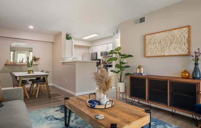 A modern living room with a grey sofa, wooden coffee table, and a large abstract art piece on the wall.