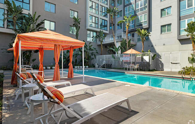 A pool area with sun loungers and a canopy.