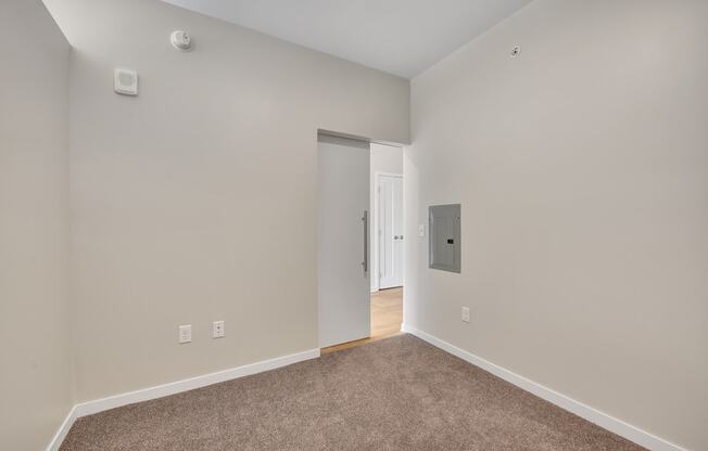 a bedroom with grey carpet and white walls