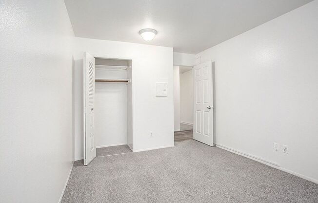 a spacious bedroom with carpet and a closet at Hampton Lakes Apartments, Michigan, 49534