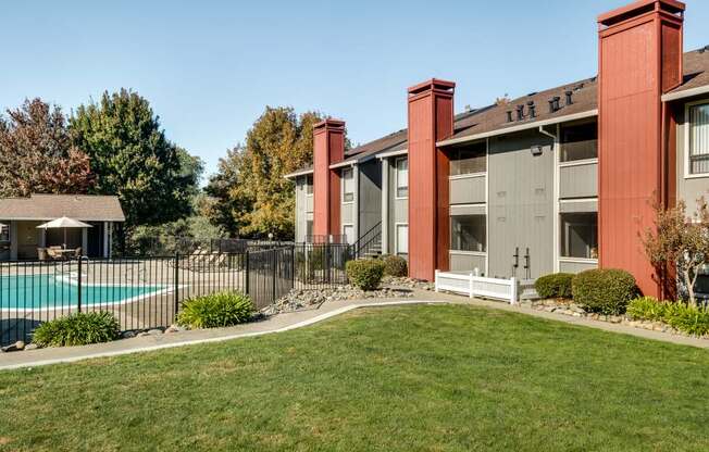A red building with a pool in front of it.