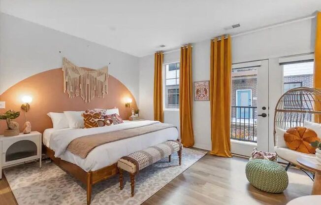 A bedroom with a large bed and a round rug.