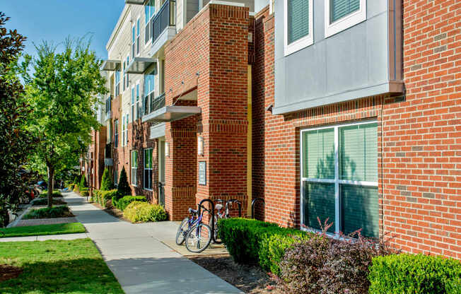 A red brick building with a bicycle parked on the sidewalk.