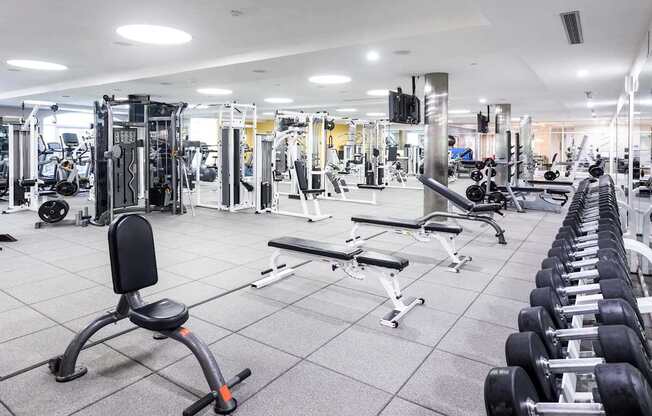 A spacious gym with a variety of equipment including treadmills, weight machines, and dumbbells. at La Jolla Crossroads Apartments, San Diego