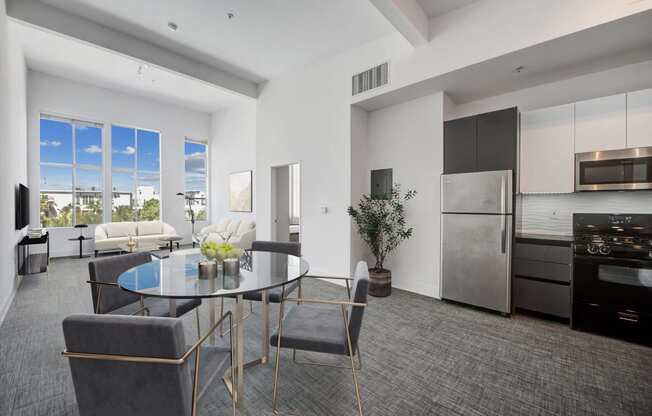 an open kitchen and living room with a table and chairs