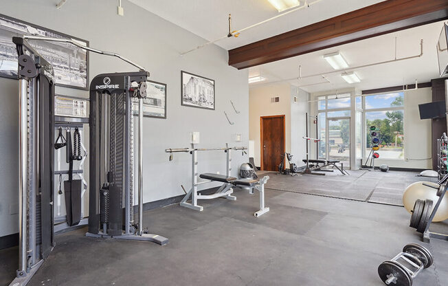 the home gym has plenty of equipment and a large window