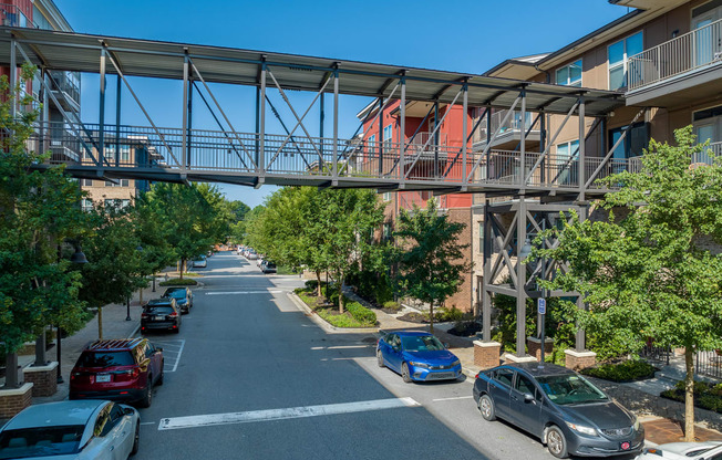 a bridge over a street with cars parked under it