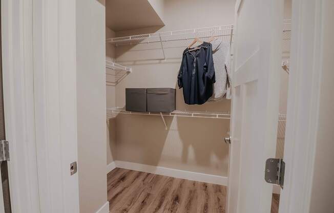 Walk-in closet with a coat hanging on the rack.