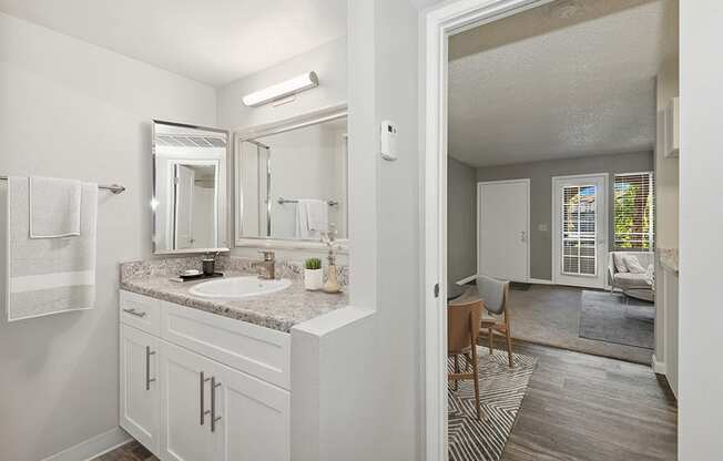 Model Bathroom with White Cabinets and Wood-Style Flooring at Stillwater Apartments in Glendale, AZ.