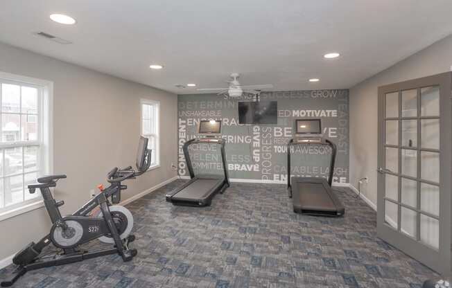 a home gym with exercise equipment and a wall with writing on it