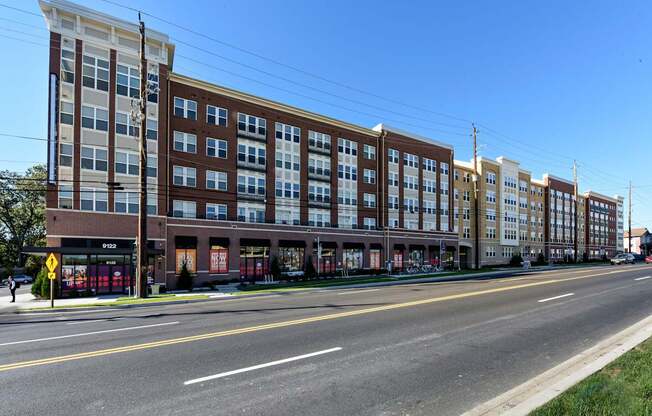 A street view of a multi-story building with a clear blue sky above.