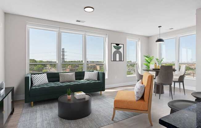 a living room with a green couch and a table with chairs