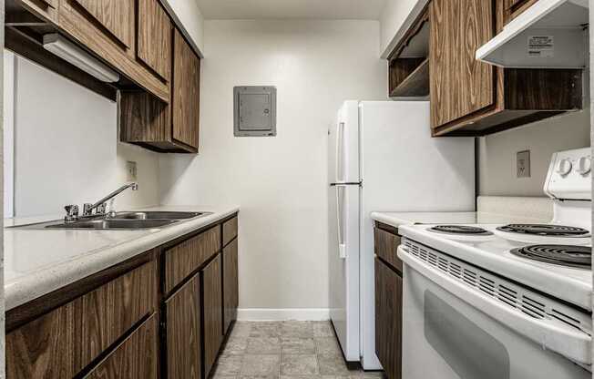 a kitchen with white appliances and wooden cabinets and a white refrigerator