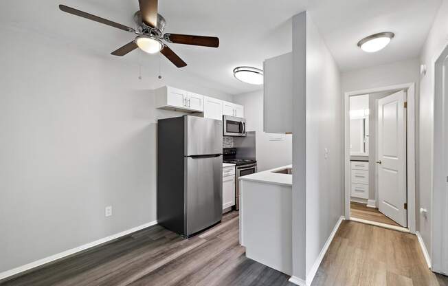 a kitchen with a refrigerator and a ceiling fan at Town & Country Apartments - Wixom, MI, Wixom, 48393