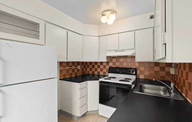 a kitchen with black counter tops and white appliances